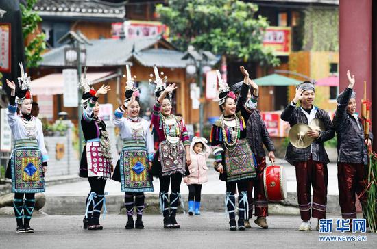 4月10日,在贵州省江口县寨沙侗寨,演员和村民送别旅客。新华社记者 杨文斌 摄