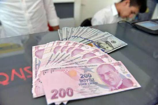  ▲8月10日，在土耳其安卡拉，一名男子展示土耳其里拉和美元纸币。 新华社发（穆斯塔法·卡亚摄）