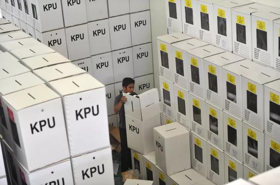 4月10日，在印度尼西亚万丹省唐格朗，一名工作人员准备选举所用物料。新华社发（祖卡南摄）