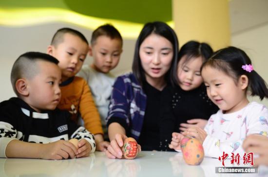 资料图：呼和浩特一所幼儿园内，小朋友正在做“立蛋”游戏。中新社记者 刘文华 摄