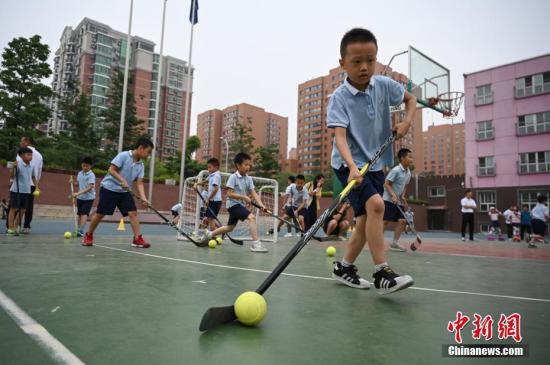 资料图:北京市中关村第三小学的学生们在校园内进行旱地冰球训练。中新社记者 崔楠 摄
