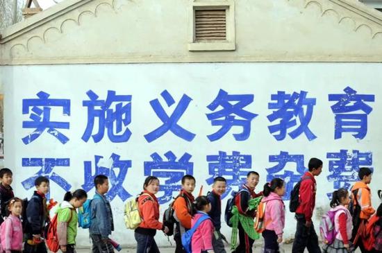  2008年3月13日，甘肃省临泽县第一小学学生放学回家。当年秋季，所有城市免除义务教育学杂费，至此我国形成了城乡统一的义务教育普惠制。（新华社图）