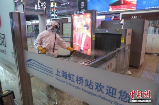 在旅客进站口,工作人员对安检设备进行消毒。张亨伟 摄
