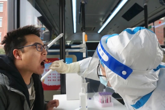 2022年1月8日，医护人员为市民进行核酸检测。当日郑州市开启第三轮全民核酸检测。（视觉中国/图）