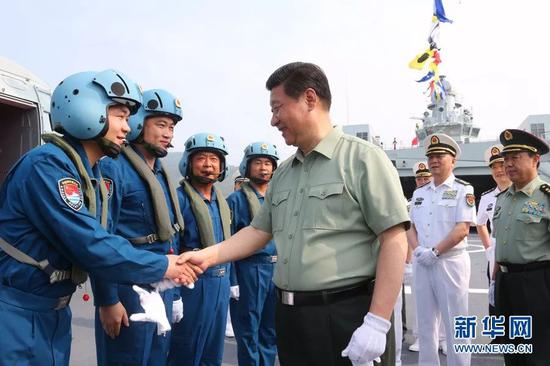 △习近平与舰载直升机飞行员亲切握手。