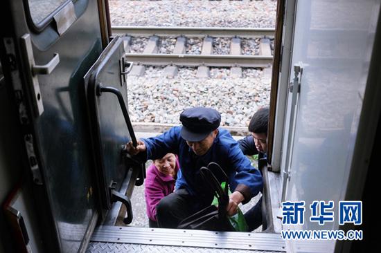 两位老人在列车员帮助下登上6905/8列车。(4月24日摄)新华网陈俊松 摄