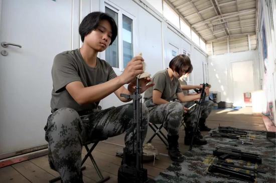 4月30日,于培杰在女兵宿舍和战友擦拭枪支。
