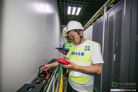 5月16日，孟繁浪和候树超正在测量南沙河节制闸自动化室蓄电池组的浮充电压（图片来源：tuku.qianlong.com）。千龙网记者 宋鹏飞摄