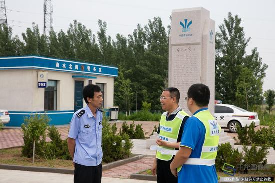 图为杨明生（中）与干渠执勤干警协商联合开展打击保护范围内沙土盗采事宜（5月16日摄 图片来源：tuku.qianlong.com）。千龙网记者 宋鹏飞摄