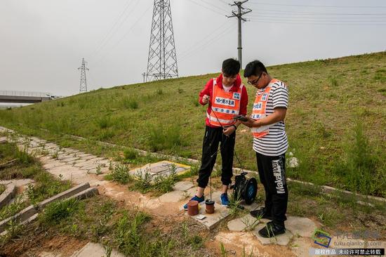 5月16日，王哲恒在渠道防护坡测量工程水平位移数据（图片来源：tuku.qianlong.com）。千龙网记者 宋鹏飞摄