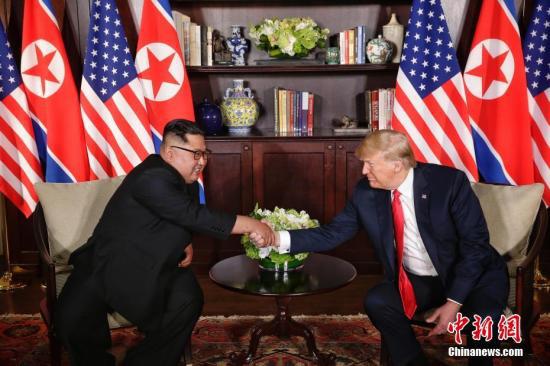6月12日，朝鲜最高领导人金正恩（左）与美国总统特朗普在新加坡举行会晤。 中新社发 新加坡通讯及新闻部供图 摄