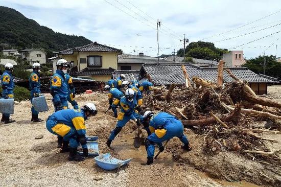 7月11日，在日本廣島吳市天應西條地區，警察清理民居附近的泥沙。（新華社記者馬平攝）