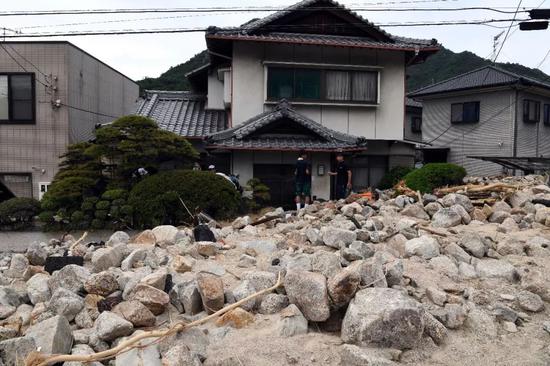 7月11日，在日本广岛吴市天应町地区，民居被泥石流部分覆盖。新华社记者马平摄