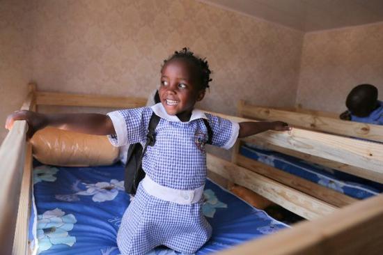 &uarr;2016年8月12日，一名津巴布韦儿童在&ldquo;非爱不可&rdquo;爱心妈妈团捐建的孤儿院内感受新的双层木板床。新华社记者 许林贵摄