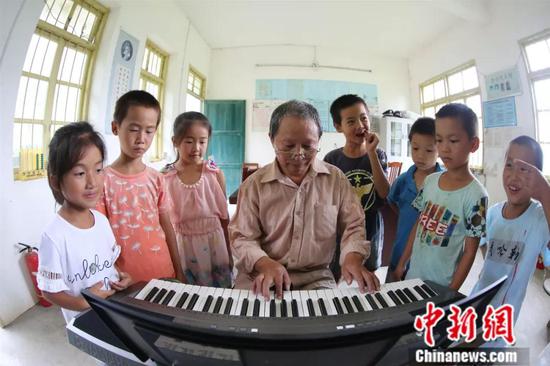 资料图：2017年9月8日，李朝文正在给孩子上音乐课。