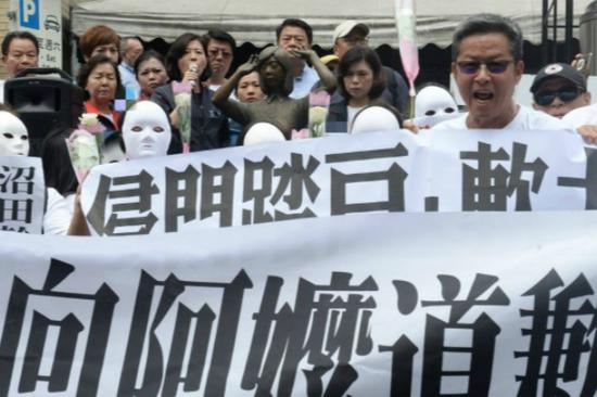 岛内民众手持横幅抗议，要求日方代表向慰安妇道歉。（图：台媒）