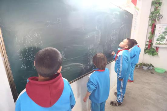 ▲20日,南疆于田县职业教育培训中心职工小学的语文课上,四名小学生被老师叫到黑板前听写生词