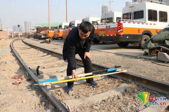 张立昌演示新型轨廓道尺与普通道尺使用区别。中国青年网记者 李川 摄