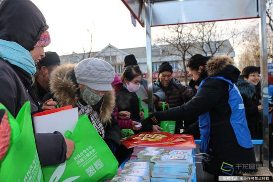 1月4日,北京市委宣传部等部门在延庆区旧县镇文体中心举办2019年北京市文化科技卫生“三下乡”集中示范活动。图为活动现场为农民群众送福送春联(图片来源:tuku.qianlong.com)。千龙网记者 张亚亚摄
