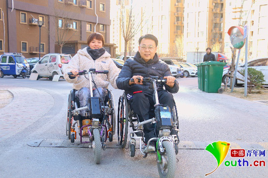 杜鹏和李春宏在小区划着轮椅并排而行。中国青年网记者李慧慧 摄