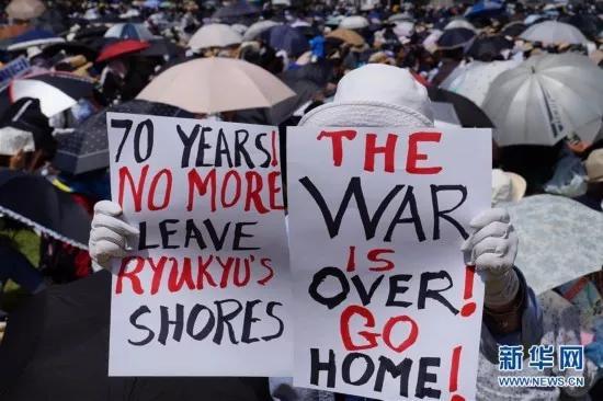 (图为民众手举标语要求美军离开冲绳,驻日美军同样风波不断,美国不得不考虑其影响)
