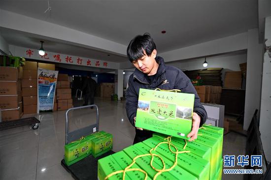 吉林省和龙市光东村,农户在搬运打包装箱后的“延边大米”(2019年2月4日摄)。 新华社记者 张楠 摄