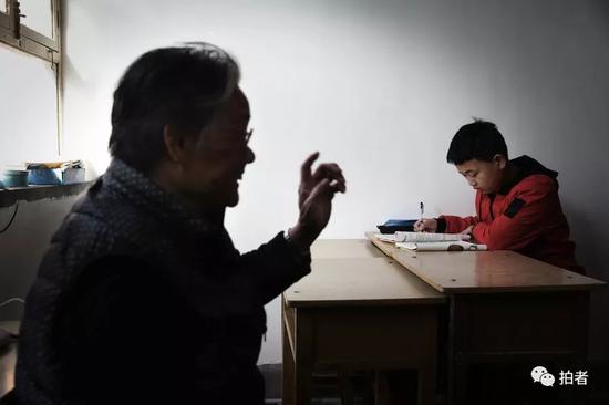 4月5日，河北涞水西官庄村，“小课桌”上，严敏文正在跟孩子交流。新京报记者尹亚飞 摄