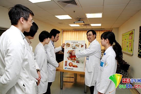姚玉峰正在给年轻医生们讲解。资料图