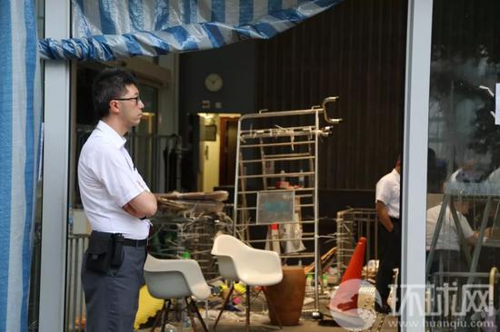 一位香港立法会的工作人员站在立法会入口处一侧,另一侧的门已经残破不堪。