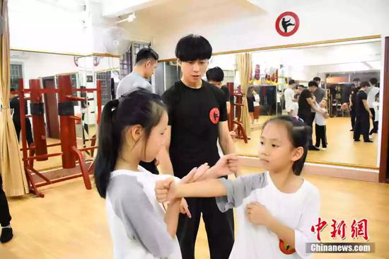 袁师傅的学员3成是女性。图为小女孩在教练的指导下学习咏春拳术。受访者供图