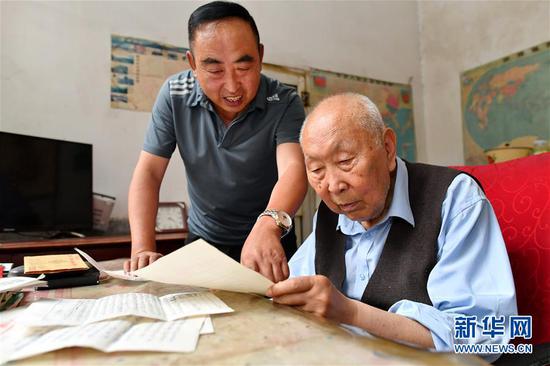 7月19日，郝郁民（右）和张玉生在翻看当年收到的反馈信件。 新华社记者 曹阳 摄