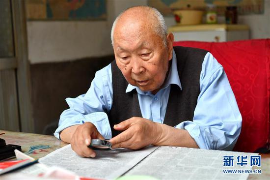 7月19日，郝郁民在家里看报纸。新华社记者 曹阳 摄