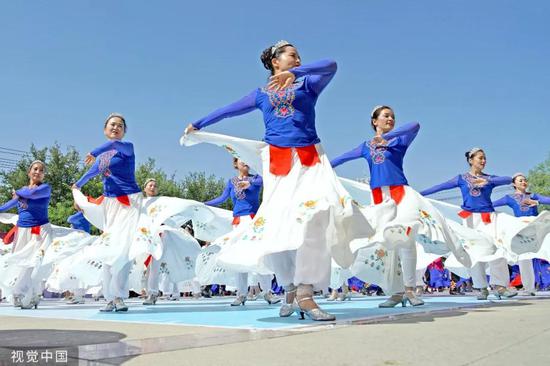 ▲8月8日，新疆哈密，市民在非物质文化遗产保护中心广场上跳民族舞。
