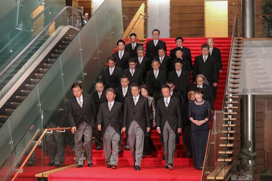 ▲9月11日，在东京首相官邸，安倍（前排中）率阁僚走下楼梯，准备合影。|视觉中国