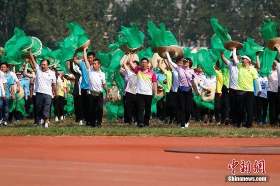 2019年9月29日，由两千多人组成的10号方阵群众在北京科技大学展开游行工作的训练任务，他们即将参加庆祝中华人民共和国成立70周年大会群众游行环节。据了解，10号方阵长54米、宽50.4米，总人数为2232人，方阵成员包括北京科技大学师生1132人，农民代表1100人，来自北京市昌平、丰台、房山三个区。中新社记者 富田 摄