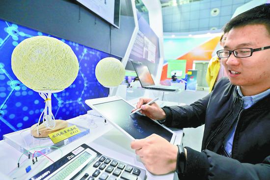 清华大学的布展工作人员介绍水汽能量收集球的工作原理