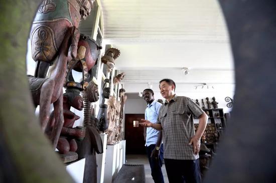  在多哥首都洛美的几内亚湾非洲国际艺术博物馆，谢燕申（右）为一名多哥游客介绍非洲艺术品。新华社记者 王腾 摄