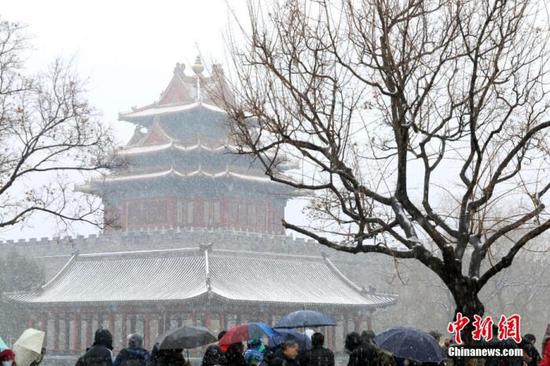 资料图：游客在北京故宫角楼欣赏雪景 （中新社记者 蒋启明 摄）