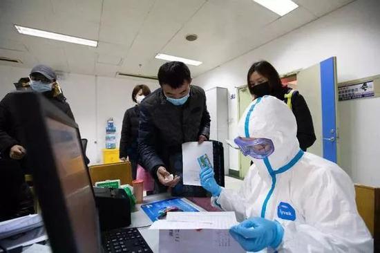 医务人员身着防护服接诊(图/中新社)