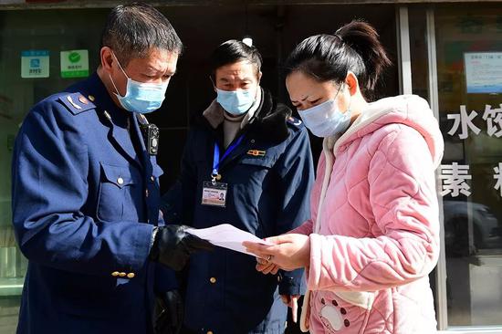 1月29日,贵阳市乌当区东风镇,市场管理人员上门与辖区经营户签订《抗击新型冠状病毒感染的肺炎疫情的责任书》。(新华社图)