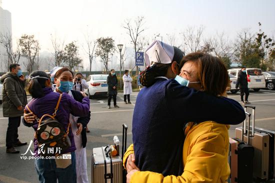 2月2日,在江苏省连云港市赣榆区人民医院,驰援武汉医疗护理队队员与同事拥抱告别。司伟/人民图片