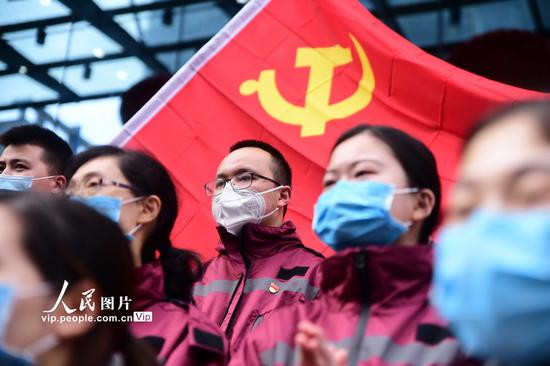 2020年2月4日,璧山区人民医院举行了“国家(重庆璧山)紧急医学救援队出征仪式”6名党员成为此次救援队的骨干,他们在党旗下合影。胡悦建/人民图片