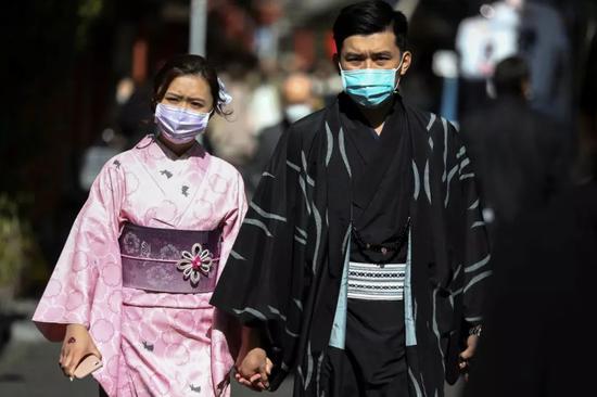 2月18日，在日本东京，两名游客戴着口罩。新华社/路透