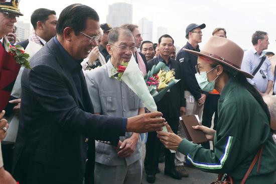  2月14日，首相洪森及其同行人员，与下船旅客密切接触时，未戴口罩。来源：美联社