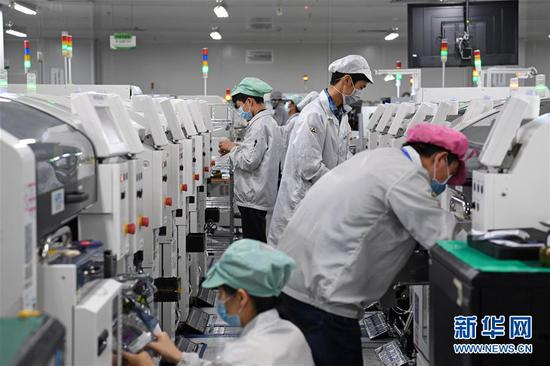 在位于深圳市龙岗区的海能达通信有限公司,工人们在生产车间工作(2月10日摄)。新华社记者 梁旭 摄