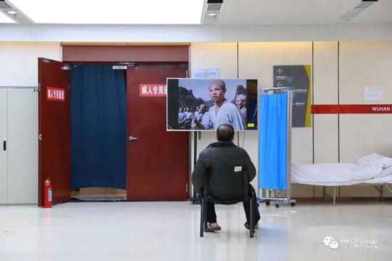 2月21日,武汉市洪山体育馆方舱医院A区内,一名患者在看电视。中青报·中青网见习记者 鲁冲/摄