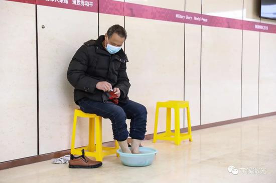2月21日,武汉市洪山体育馆方舱医院A区内,一名患者在泡脚,他筹办换上新的袜子。中青报·中青网见习记者 鲁冲/摄