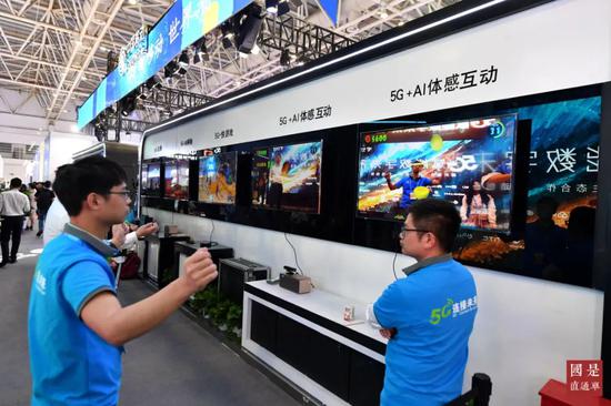 (资料图)中国移动展台的工作人员在演示5G应用。中新社记者 吕明 摄