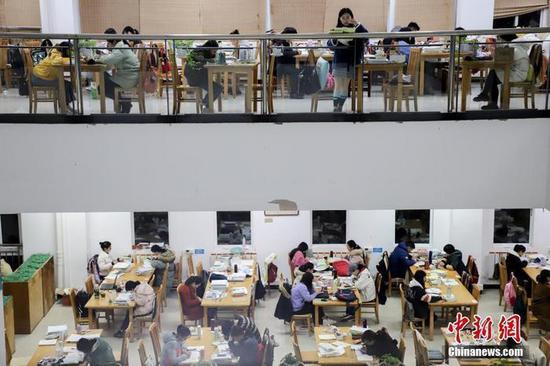 资料图:考研学生正在看书复习。 中新社记者 瞿宏伦 摄
