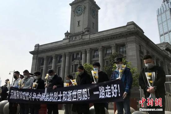 4月4日，民众在武汉江汉关大楼前默哀。中新社记者 张芹 摄